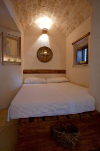 a bedroom with a large bed with a light above it at I Trulli Di Acquarossa in Cisternino