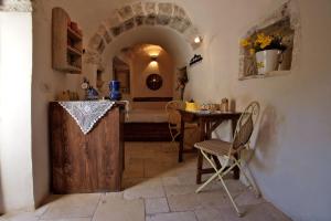 a room with a table and a wooden door at I Trulli Di Acquarossa in Cisternino