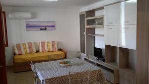 een kleine woonkamer met een tafel en een bank bij Casa vacanze Mare in Parghelia