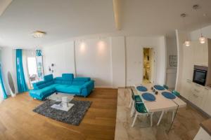 a living room with a blue couch and a table at Apartment Mimosa of Tre Canne in Budva