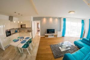 a living room with a blue couch and a table at Apartment Mimosa of Tre Canne in Budva