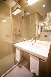 a bathroom with a sink and a shower and a mirror at Hotel Moov Curitiba in Curitiba