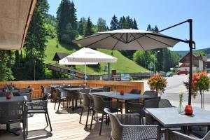 a patio with tables and chairs and an umbrella at Residence Post in Pec pod Sněžkou