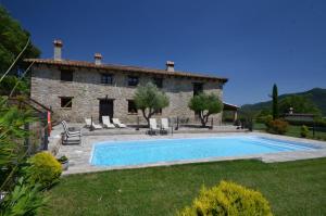 une maison en pierre avec une piscine en face de celle-ci dans l'établissement Mas Planella Casa Rural, à Mieras