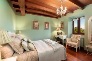 a bedroom with a bed and a desk and a chandelier at Casa de Aldea con Piscina Calefactada opcional - CA-1451-AS in Villaviciosa +68 photos