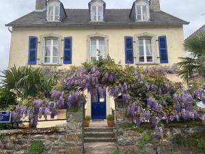 una casa con fiori viola sulla parte anteriore di St Guenole' Studio Apartment a Landévennec