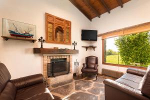 a living room with a couch and a fireplace at Casa de Aldea con Piscina Calefactada opcional - CA-1451-AS in Villaviciosa