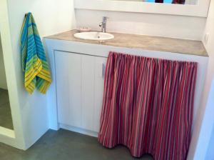 ein Bad mit einem Waschbecken und einem roten Handtuch in der Unterkunft Casa da Âncora - Comporta in Comporta + 15 Fotos