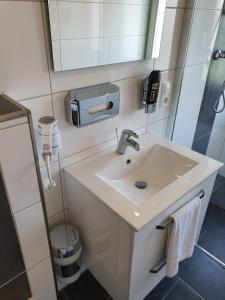 een badkamer met een wastafel en een spiegel bij Nordseehotel Apartments in Wilhelmshaven