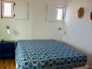 ein Schlafzimmer mit einem Bett und zwei Fenstern in der Unterkunft Casa da Âncora - Comporta in Comporta