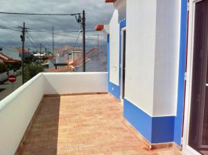einen Balkon mit einer blau-weißen Wand und einer Tür in der Unterkunft Casa da Âncora - Comporta in Comporta