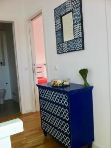 eine blaue Kommode in einem Zimmer mit einem Spiegel in der Unterkunft Casa da Âncora - Comporta in Comporta