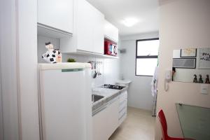 cocina con armarios blancos y nevera en FLAT BOA VIAGEM PRÓXIMO A PRAIA, en Recife