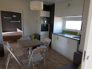 a small kitchen and dining room with a table and chairs at Village Guerzaille in Saint-Caradec