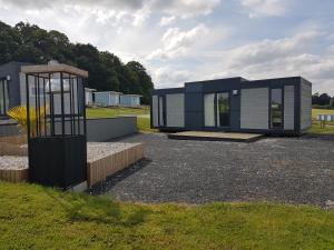 una casa moderna in un campo con un edificio di Village Guerzaille a Saint-Caradec