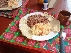 a plate of food with guacamole and chips on a table at Beach Hostal Oasis in Las Peñitas