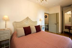 コンドンにあるLes Hauts de Condom Appartements Climatisesのベッドルーム1室(大型ベッド1台、シャンデリア付)