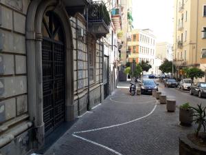 uma rua vazia com carros estacionados ao lado de um edifício em Casa Vacanze Basso em Salerno