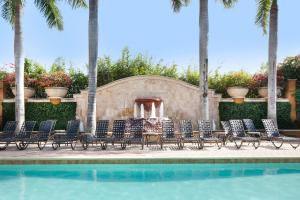 a swimming pool with chairs and a fountain at Bellasera Resort in Naples