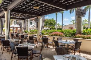 a restaurant with tables and chairs on a patio at Bellasera Resort in Naples