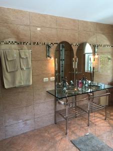 a bathroom with two sinks and two mirrors at Casa Coral Sosua in Sosúa
