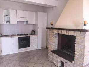 アッシジにあるB&B Villa Sophieの暖炉と白いキャビネット付きのキッチン