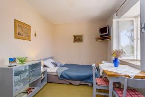 Kleines Zimmer mit einem Bett und einem Tisch in der Unterkunft SheShe in Mali Lošinj