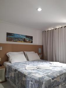 ein Schlafzimmer mit einem Bett mit einer blauen und weißen Decke in der Unterkunft Imo Apart Pipa's Ocean in Pipa