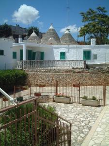 a fence in front of a house with some plants at The Sea View Mountain Apartment in Fasano