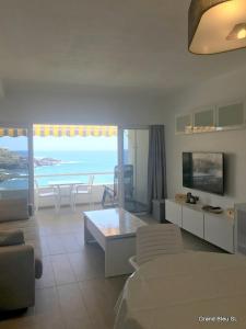 a living room with a view of the ocean at El Ancla - El Mar y La Playa in Callao Salvaje +16 photos