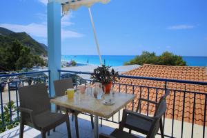 a table on a balcony with a view of the ocean at Kathisma Studios Apartments-Theochari Angeliki GP in Agios Nikitas
