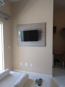 a flat screen tv on a wall in a bedroom at Hotel Costa do Delta in Tutóia
