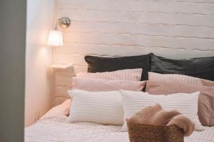 a bedroom with a bed with pink and white pillows at Casas do Lago in Estremoz