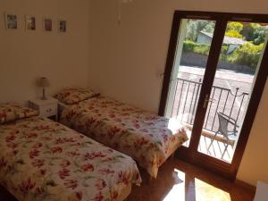 a bedroom with two beds and a door with a balcony at Apartment Olive & Kin, Collioure in Collioure