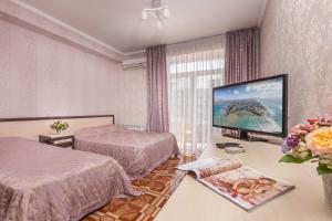 a hotel room with two beds and a flat screen tv at Посейдон-3, отель in Vityazevo