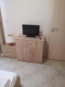 une chambre avec une télévision sur une commode avec une porte dans l'établissement Private apartment in Emberli Aparthotel, à Lozenets