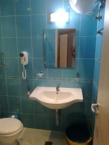 La salle de bains est pourvue d'un lavabo, de toilettes et d'un miroir. dans l'établissement Private apartment in Emberli Aparthotel, à Lozenets