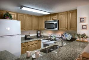 a kitchen with a white refrigerator and a sink at Carolina Winds in Myrtle Beach