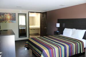 a hotel room with a bed and a bathroom at Castle Inn East Greenbush Castleton-on-hudson in East Greenbush