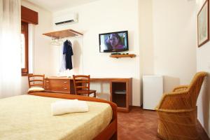 a bedroom with a bed and a desk and a tv on the wall at Country Villa San Vito Bay in San Vito lo Capo