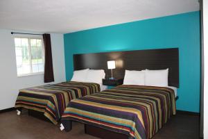 two beds in a hotel room with blue walls at Castle Inn East Greenbush Castleton-on-hudson in East Greenbush +4 photos