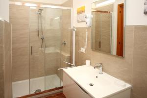 a bathroom with a sink and a shower with a glass door at Country Villa San Vito Bay in San Vito lo Capo