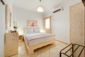 a bedroom with a bed and a chair in it at Akrotiri Apartments in Akrotiri +79 photos