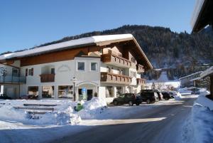 a large building with snow on the side of a street at Apartments Hartsleben in Flachau