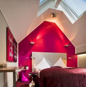 a bedroom with a red wall and a bed at Malerwinkel Hotel in Bergisch Gladbach