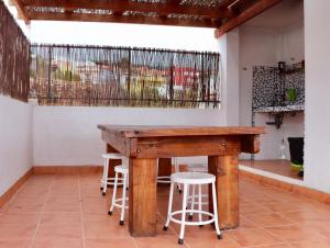 a wooden table in a room with stools at Casa Yoel in Granadilla de Abona