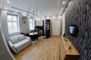 een woonkamer met een bank, een tafel en een tv bij Apartmani Galea in Sombor