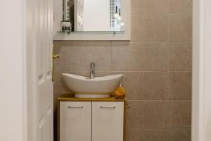 un bagno con lavandino e specchio di Apartmani Galea a Sombor Altre 37 foto