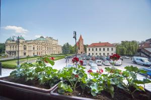 - une vue sur un parking avec des fleurs dans un planteur dans l'établissement Pollera, à Cracovie