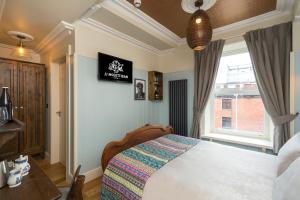 a bedroom with a bed and a window at McGettigan's Townhouse - Olives & Figs Bistro in Dublin